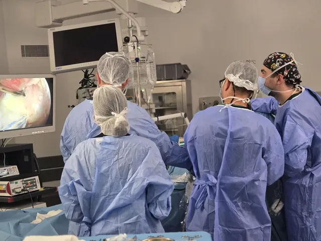 A surgical team working during an arthroscopic procedure in an operating room
